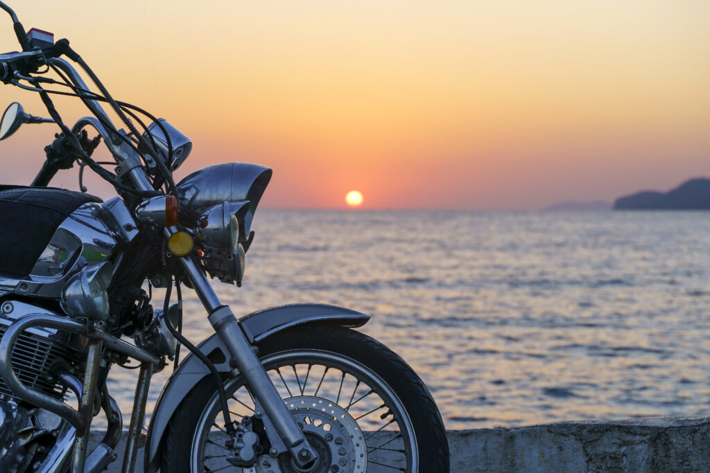 Motorcycle on the sea pier during a beautiful sea sunset. Travel, adventure, vacation concept. High quality photo